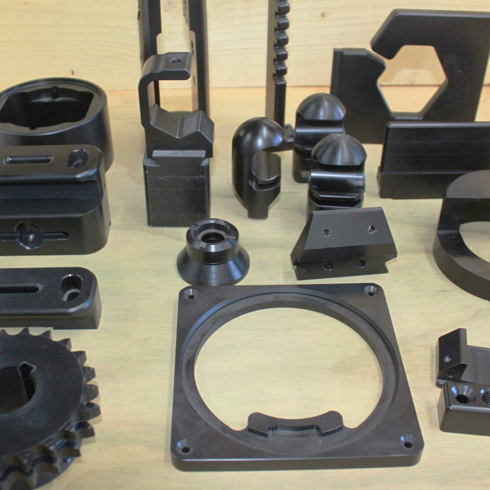 Black machined components arranged on a workbench